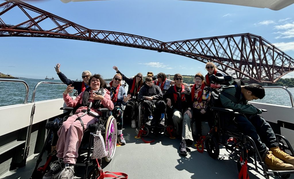 A group of people on Wet Wheels posing for a picture underneath the Forth Rail Bridge
